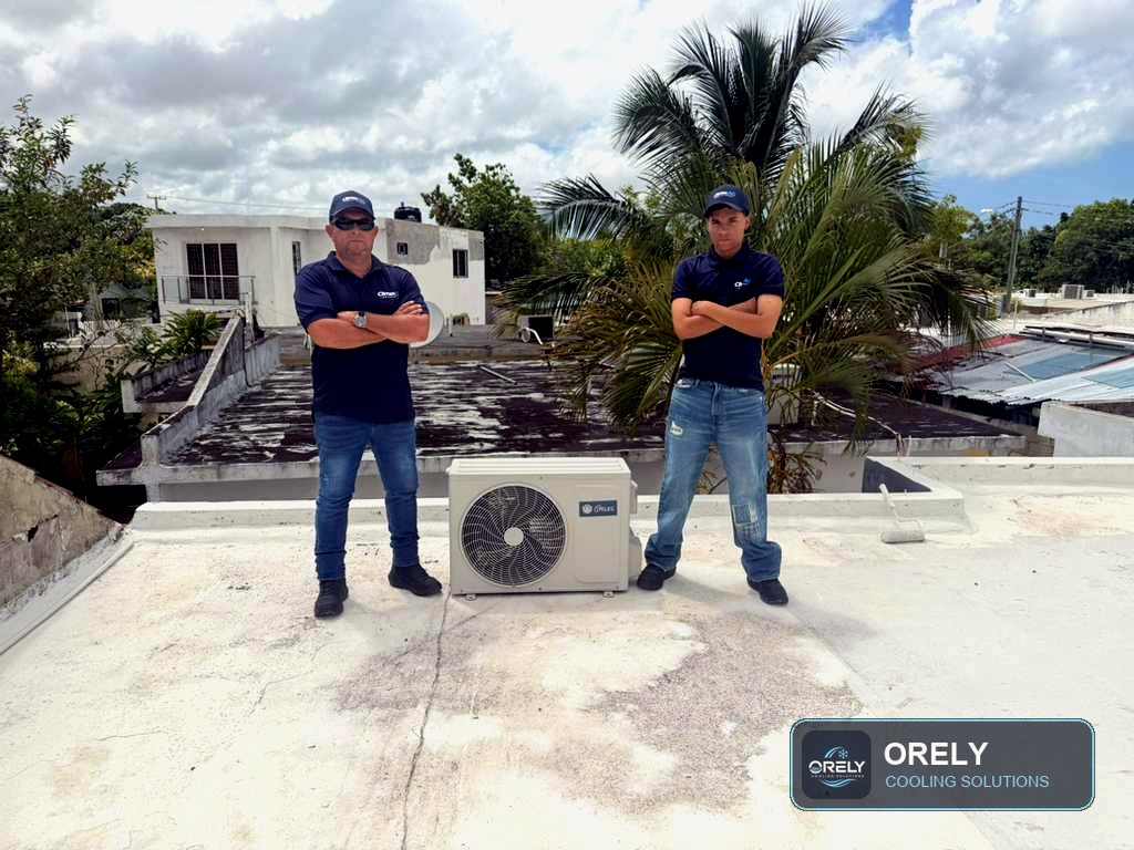 ORELY technicians standing with an outdoor AC unit